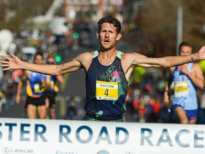 A runner crosses the finish line at the Manchester Road Race, sponsored by ECPC.